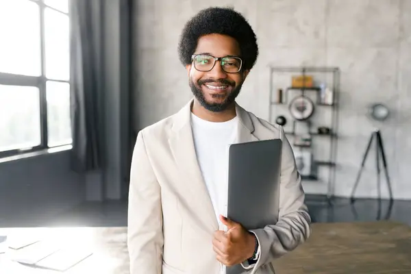 Brazylijski Biznesmen Uśmiecha Się Ciepło Trzymając Laptopa Jednej Ręce Stojąc — Zdjęcie stockowe