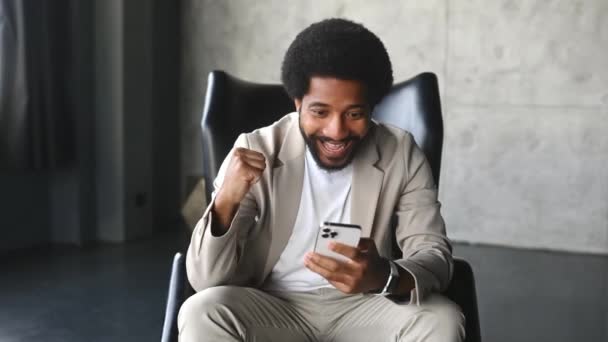 Egy Üzletember Egy Sikeres Pillanatot Ünnepel Miközben Okostelefonját Nézi Öklét — Stock videók