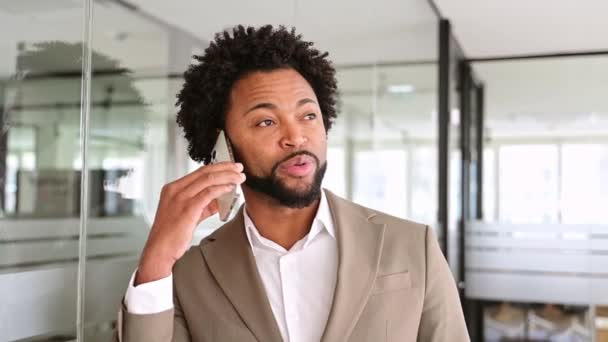 Thoughtful African American Businessman Holds Phone Conversation Bright Modern Office — Stock Video