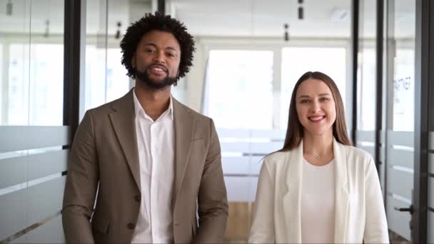 现代商人和女商人都穿着时髦的办公室服装 背靠背地站在那里 带着自信的微笑 象征着职业环境中的团结和相互支持 积极的工作关系 — 图库视频影像