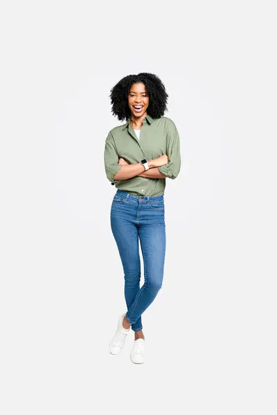 一位穿着橄榄绿衬衫和牛仔裤的泰然自若的美籍黑人女性自信地站得满满的 她迷人的笑容和休闲却又职业化的装束表明了她的现代风格和商业头脑的结合 — 图库照片