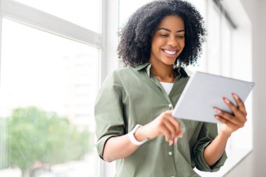 İyimser, mutlu, Afro-Amerikan çekici bir kadın. Parlak bir odada tabletle internetten iletişim kuruyor ya da boş zamanlarında kitap okuyor.