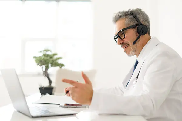 Starszy Lekarz Siwymi Włosami Entuzjazmem Wyjaśnia Koncepcję Podczas Sesji Telezdrowia — Zdjęcie stockowe