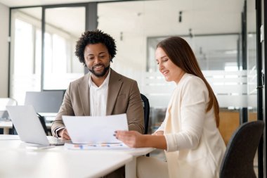 İki iş arkadaşı, şirket ortamında takım çalışması ve işbirliği anlamına gelen evrak işleriyle ilgili yapıcı bir tartışmaya giriştiler..