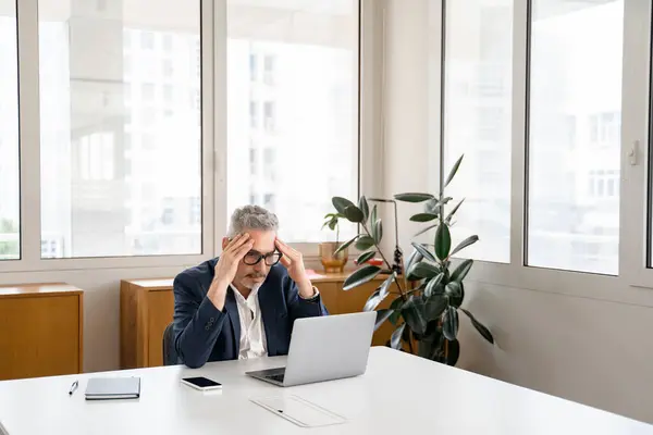 心配している成熟した男性の従業員同僚は 職場に座ってノートパソコンの画面を見ている 年金懸念ビジネスマンは プロジェクトに問題を抱えています 新しいアイデアの欠如 問題を解決する — ストック写真
