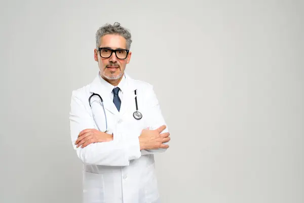 Senior Doctor Presents Strong Assuring Presence Arms Folded Serious Expression Stock Photo