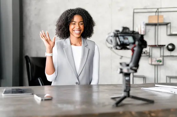 Charming Businesswoman Smiles Warmly Camera Her Hand Gesture Suggesting Friendly Stock Image
