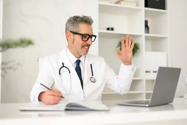 Cheerful Senior Doctor Engages Virtually Patients Colleagues Using Hand Gestures — Stock Photo, Image