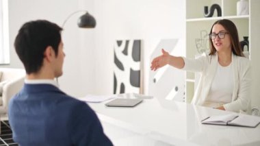 Modern bir ofiste iş arkadaşları el sıkışıyor. Tokalaşma, başarılı bir iş anlaşmasını ya da olumlu bir iş görüşmesinin sonunu simgeliyor. Profesyonellik, başarı ve ortaklık