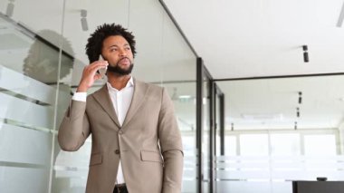 İş adamı bir telefon görüşmesi yapıyor, önemli iş konularını tartışıyor, çağdaş bir ofis alanı zeminiyle, olumlu diyalog kuruyor, anlaşma imzalıyor veya yeni bir ortaklık kuruyor.