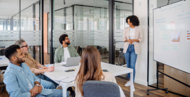 Kendine güvenen bir kadın profesyonel, şirket yönetim kurulundaki farklı bir takıma stratejik bir plan sunuyor. Tartışmada çalışma ortamında liderlik, takım çalışması ve iş geliştirme vurgulandı.