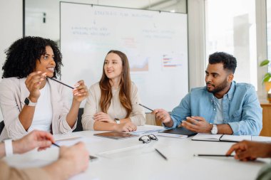 İş adamları bir şirket toplantısı sırasında aktif olarak fikir ve stratejileri tartışıyor. İş adamları bir şirket toplantısı sırasında aktif olarak fikir ve stratejileri tartışıyor.