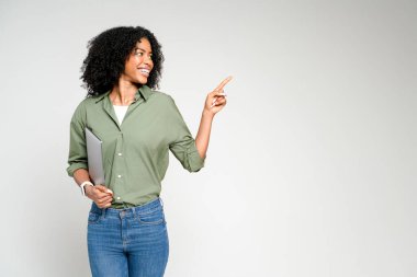 Gülümseyen bu Afro-Amerikalı kadın elinde bir tablet tutuyor ve boş bir alana işaret ediyor. Fikirleri kavramsallaştırmak ya da görsel içeriği açık ve ilgi çekici bir şekilde sunmak için ideal..