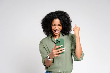 Zafer anına yakalanan bu kadın, akıllı telefon ekranına muzaffer bir tepki veriyor. Bulaşıcı, başarı teması ve dijital kazanç için mükemmel.