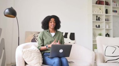 Kadın bir video görüşmesi sırasında hareketli bir şekilde konuşuyor, elleri, modern uzaktan çalışmanın etkileşimli doğasını vurgulayarak ne demek istediğini açıkça ifade ediyor. Video çağrısı kavramı