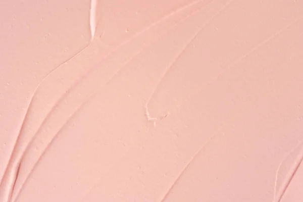 Pink cosmetic clay smudged background. Pink shimmering cosmetic texture background. Pink clay cosmetic mask textured smears close up. Cosmetic clay for face and body skin care procedures.