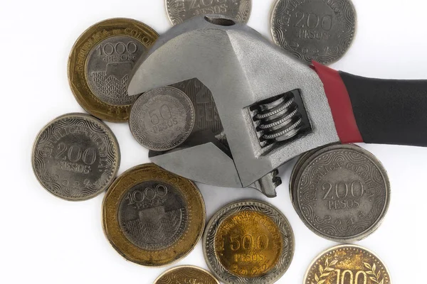 Haufen Kolumbianischer Münzen Und Ein Verstellbarer Schraubenschlüssel Auf Weißem Hintergrund — Stockfoto
