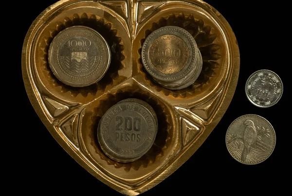 黒を背景にコロンビアのコインでハート — ストック写真