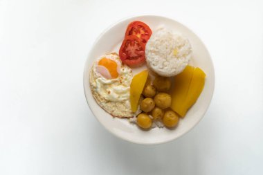 Kızarmış pirinçli yumurta domates ve beyaz arka planda patates.