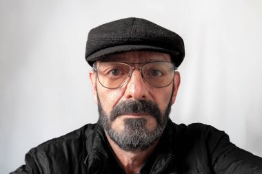 Gri sakallı orta yaşlı bir adamın yüzü.