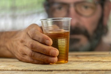 Cam tutan adam, alkol yüzünden zorlanıyor.