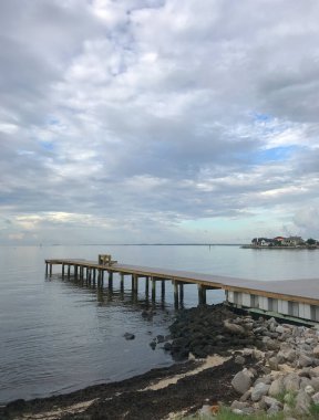 Florida 'daki Pensacola Körfezi' nde boş, huzurlu bir balıkçı iskelesi. Suyun kenarı kıyı şeridinin dengelendiğini gösteriyor..