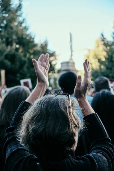 aged woman clapping hands during the protest of woman rights