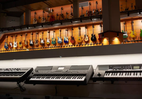 鍵盤とピアノとギターの楽器店のショーケース — ストック写真