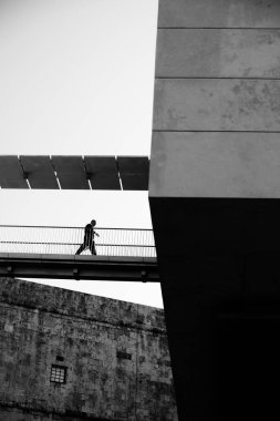 businessman walking in a stairway suspended between two buildings