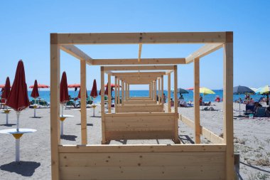 Cagliari, Sardinya 'daki Poetto Plajı' nda berrak mavi bir gökyüzü ve arka planda sakin bir deniz olan canlı bir büfe.