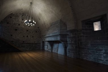 Verrs, Aosta Vadisi, İtalya - 28 Temmuz 2025 Verrs Kalesi içindeki gotik tarzda bir odanın iç manzarası, yüksek kemerli tavan, kırsal avize ve doğal ışıkla aydınlatılmış taş duvarlar.