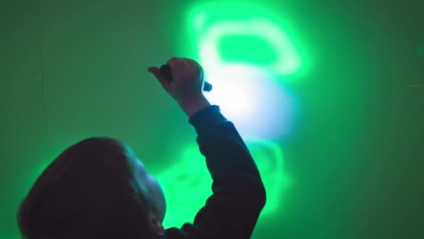 Інтерактивні Ігри Дітей Радісний Хлопчик Малює Візерунки Стіні Ліхтариком Використовуючи — стокове відео