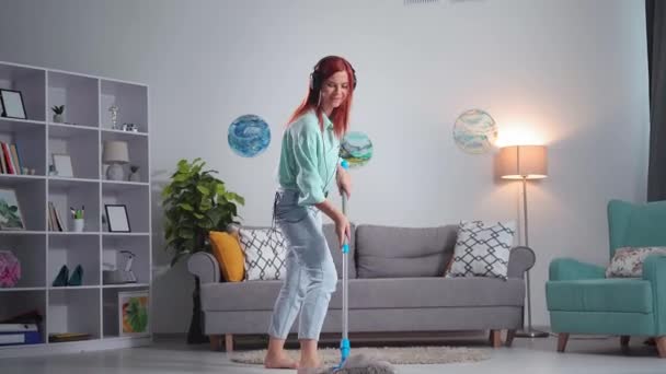 House Cleaning Joyful Young Woman Headphones Uses Mop Washes Laminate — Vídeos de Stock