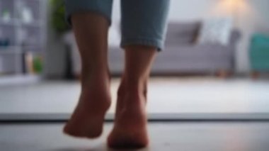 beautiful female legs walk on clean light laminate flooring in living room