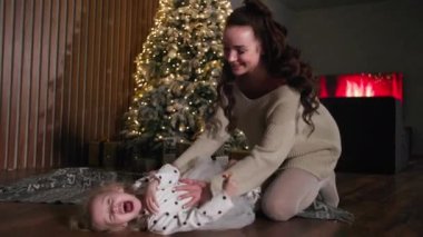 carefree childhood, little cute girl having fun with her mom while spending time together at christmas party in evening at home