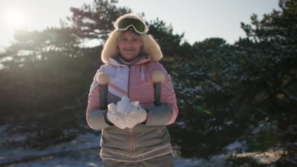 Pensioner Cheerfully Throws Snowballs While Walking Winter Forest City Backdrop — Stock Video