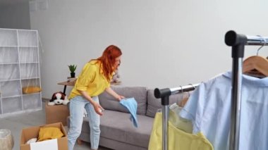 Evi terk eden kadın mülteciler, kenti boşaltırken kutuya ve sırt çantasına giysilerini koyup kameraya bakıyorlar.