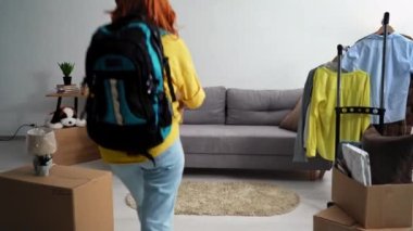 Mülteciler, eve dönen kadınlar eşyalarla dolu kutular yerleştirip koltuğa oturur, Ukrayna bayrağı çeker kanepeye oturur, gülümser ve kameraya bakar.