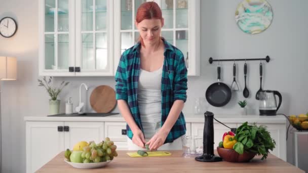 Charming Woman Tossing Fresh Cucumber Adding Lettuce Leaves Blender While — Vídeos de Stock