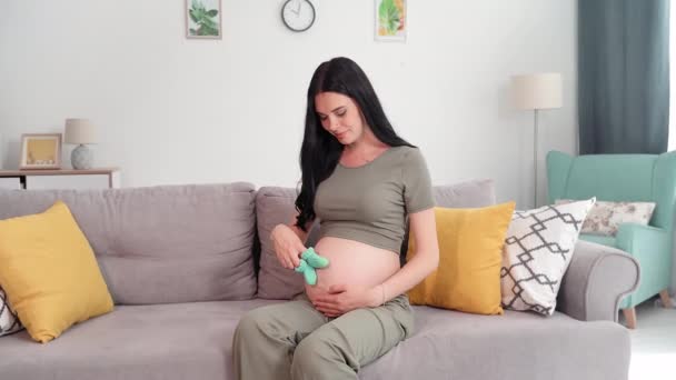 母亲的肖像 孕妇的肖像 她的大的赤身裸体的肚子坐在沙发上 微笑着看着相机 — 图库视频影像