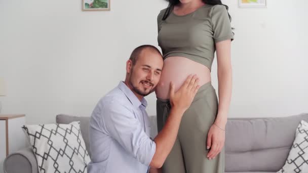 Mutlu Genç Babanın Portresi Hamile Kadının Karnındaki Bebeği Dinlemekten Zevk — Stok video