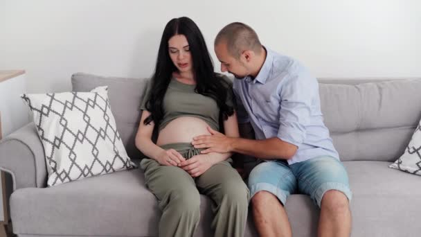 Pregnancy Parents Watching Baby Belly While Sitting Sofa Room — Stok video