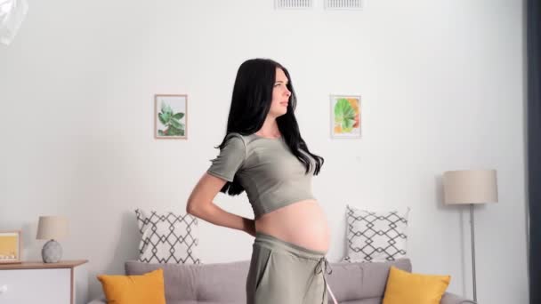 測定器を持つ魅力的な若い妊婦は家で赤ちゃんと大きな腹を測定し 笑顔とカメラを見て — ストック動画