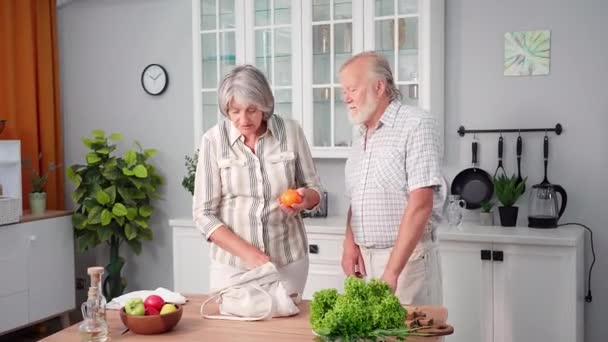 素食主义 老人和女人从生态食品袋里取出新鲜黄瓜和西红柿 放在桌上的沙拉放在厨房里 — 图库视频影像