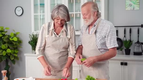 老年人一起在厨房的桌子上把新鲜蔬菜沙拉切成薄片 玩得很开心 — 图库视频影像