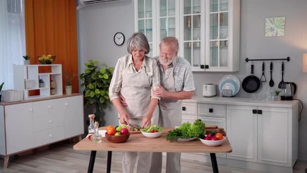 Starší Muž Objímající Svou Ženu Při Přípravě Večeře Krájení Čerstvé — Stock video