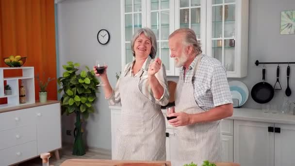在厨房准备浪漫晚餐的时候 快乐的老丈夫和笑容满面的老妇人欢欢喜喜地跳舞 — 图库视频影像
