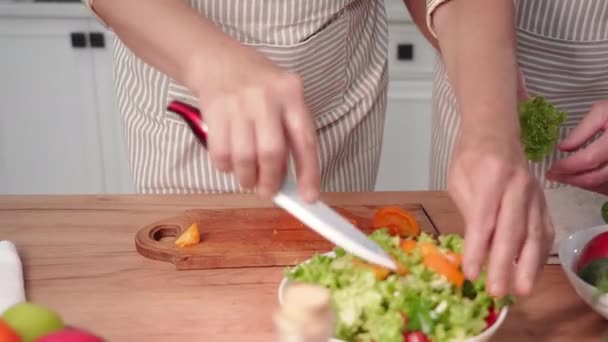 健康食品 老夫老妻切健康可口的西红柿在厨房里准备沙拉 — 图库视频影像