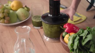 Yeşil meyve püresi hazırlama süreci, sebzeler elektrikli blender ile doğranır, yakın plan.