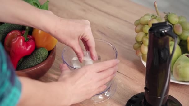 年轻的家庭主妇组装搅拌机 在厨房桌子上切蔬菜和水果 — 图库视频影像